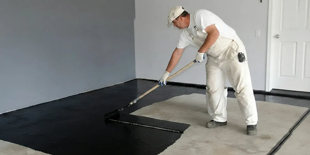 basement waterproofing professional applying waterproof coating to protect a basement floor in Jacksonville, FL